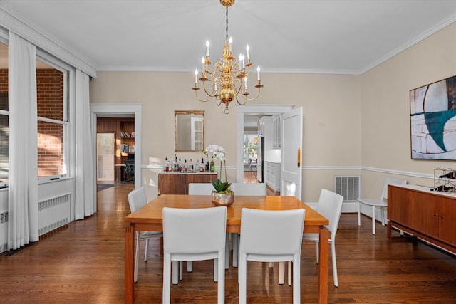 dining area featuring visible vents, wood finished floors, and ornamental molding