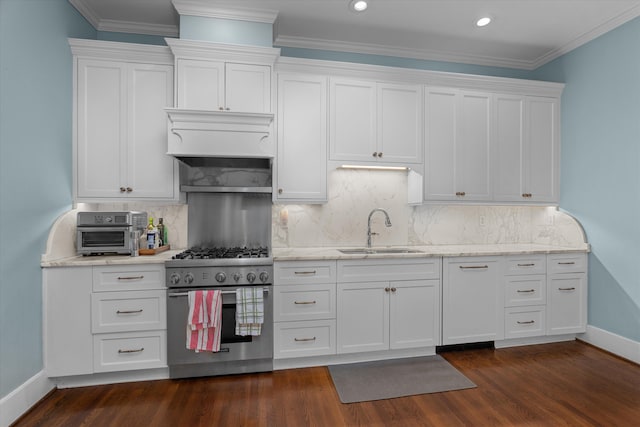 kitchen with white cabinets, decorative backsplash, dark wood-style floors, high end range, and a sink