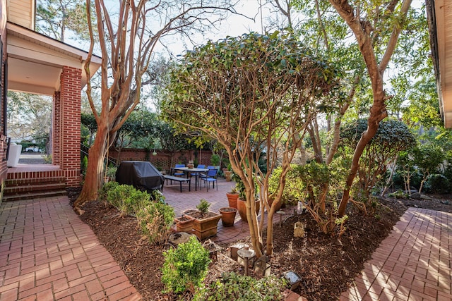 view of patio featuring a grill, fence, and outdoor dining space