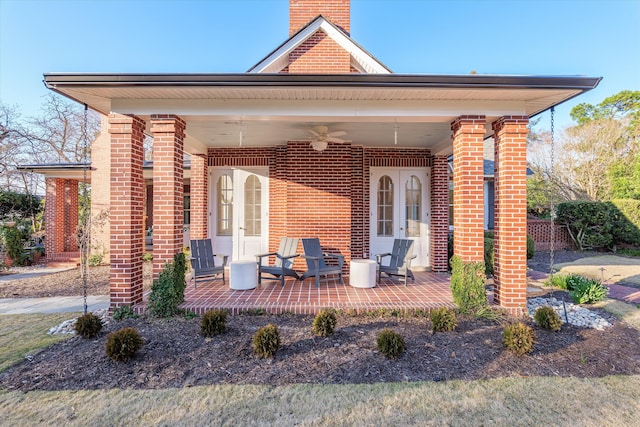 back of house with french doors, a chimney, and brick siding