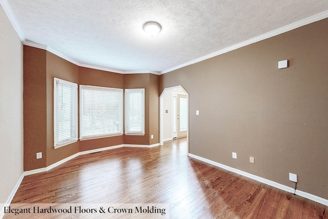 spare room with wood-type flooring, ornamental molding, and a textured ceiling