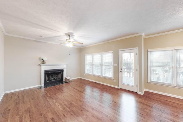 unfurnished living room featuring hardwood / wood-style floors, crown molding, a textured ceiling, and ceiling fan