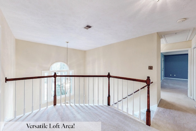 hall with lofted ceiling, light carpet, and a textured ceiling