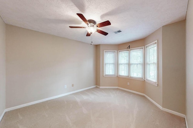 carpeted empty room featuring ceiling fan and a textured ceiling