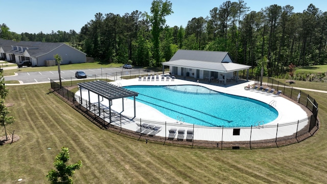 pool featuring a yard, a patio, and fence