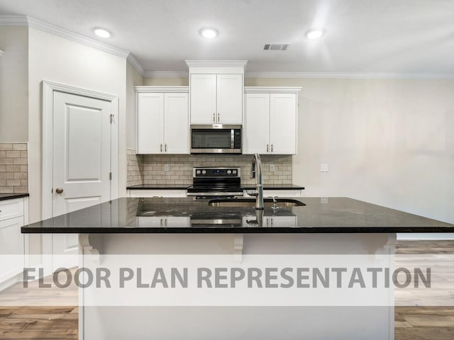 kitchen with visible vents, stainless steel appliances, light wood-type flooring, white cabinetry, and a sink