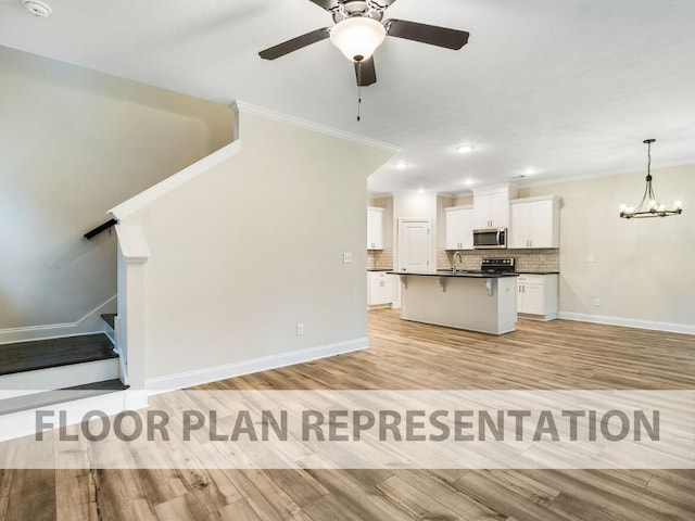 kitchen with tasteful backsplash, dark countertops, stainless steel microwave, open floor plan, and a kitchen breakfast bar