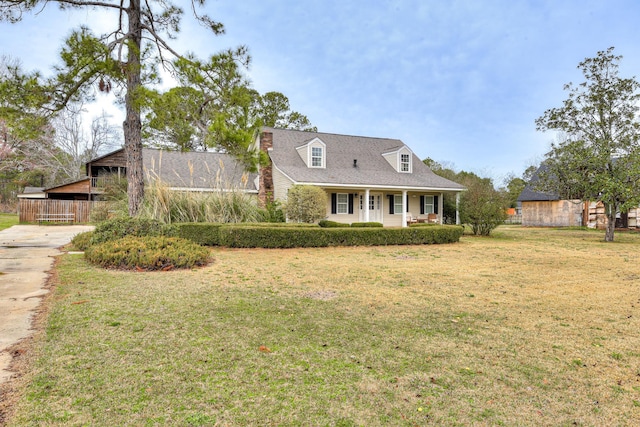 cape cod home with a front yard and a porch