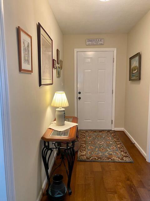 doorway to outside featuring wood finished floors and baseboards