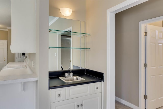 bar with crown molding, baseboards, and a sink