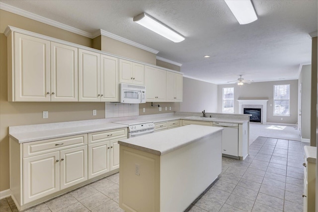 kitchen with white appliances, ornamental molding, open floor plan, a center island, and light countertops