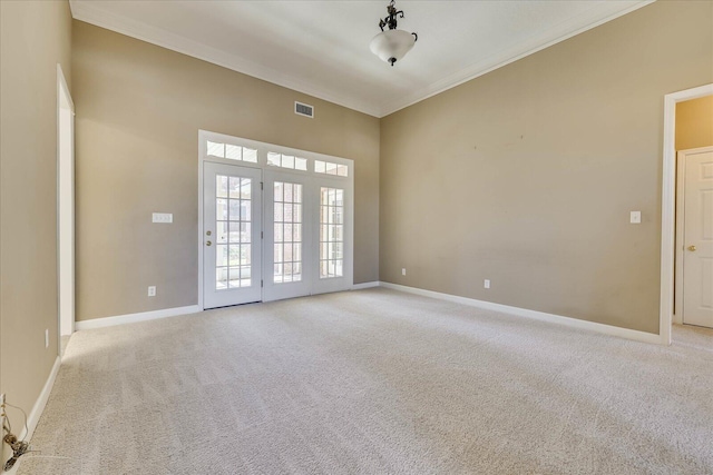 empty room featuring visible vents, crown molding, light carpet, and baseboards