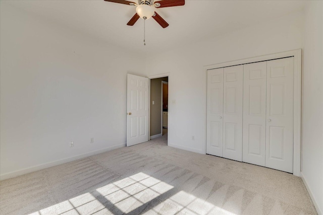 unfurnished bedroom with ceiling fan, baseboards, a closet, and light colored carpet