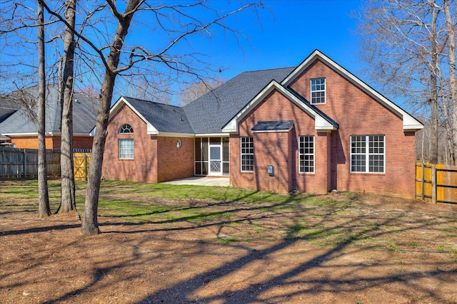 rear view of house with a patio, brick siding, a lawn, and a fenced backyard