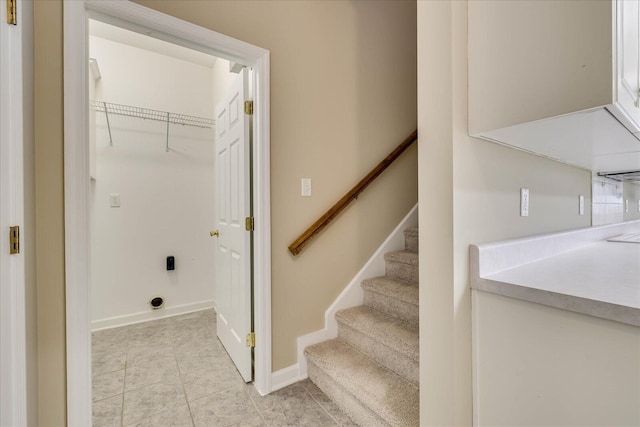 clothes washing area featuring baseboards and light tile patterned floors