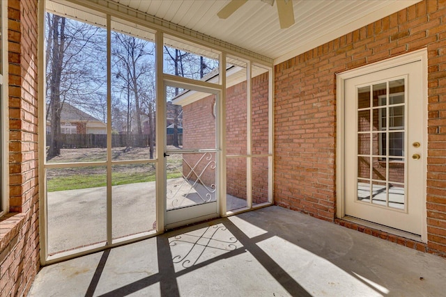 unfurnished sunroom featuring ceiling fan