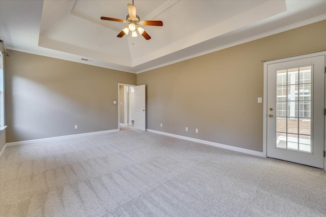 empty room with light carpet, baseboards, and a raised ceiling