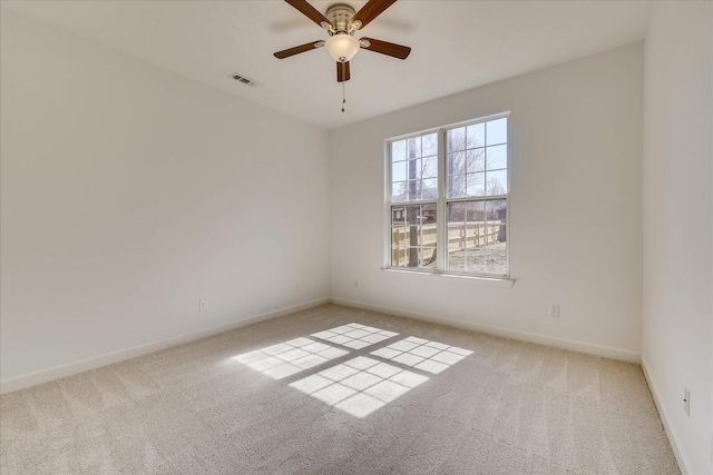 unfurnished room featuring baseboards, a ceiling fan, visible vents, and light colored carpet