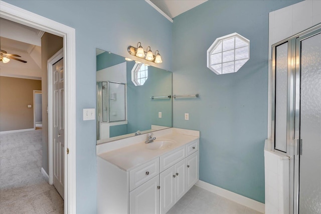 bathroom with baseboards, ceiling fan, tile patterned floors, a shower with shower door, and vanity