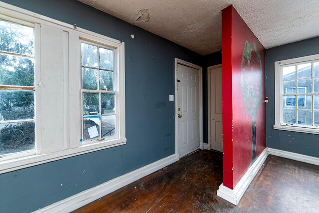 entrance foyer with dark hardwood / wood-style floors and a textured ceiling