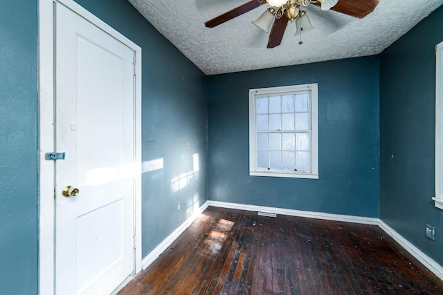 unfurnished room with ceiling fan, dark hardwood / wood-style flooring, and a textured ceiling