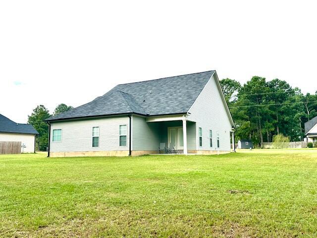 rear view of house featuring a yard