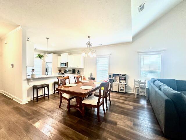 dining room with a chandelier, dark hardwood / wood-style flooring, and ornamental molding