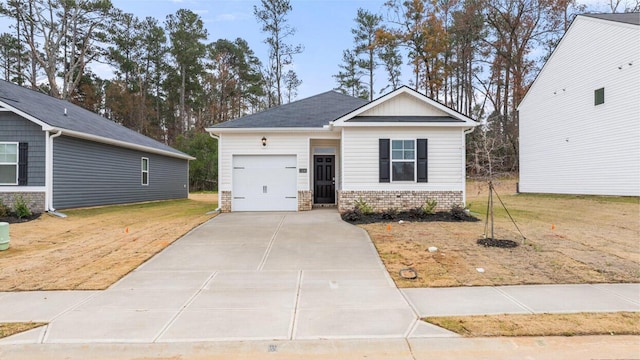 craftsman inspired home featuring a garage, a front yard, brick siding, and driveway