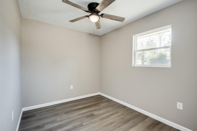 empty room featuring a ceiling fan, baseboards, and wood finished floors