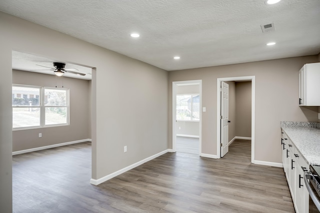 interior space with plenty of natural light, baseboards, and light wood-style flooring