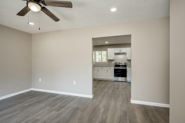 interior space featuring light wood-style flooring, baseboards, and a textured ceiling