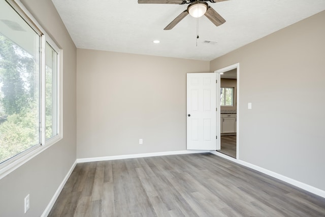 spare room featuring plenty of natural light, visible vents, and baseboards