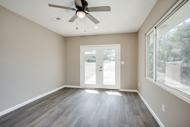 unfurnished room with dark wood-style flooring, french doors, visible vents, a ceiling fan, and baseboards