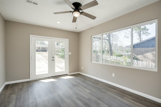 empty room featuring french doors, visible vents, ceiling fan, wood finished floors, and baseboards