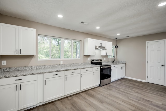 kitchen with under cabinet range hood, a sink, stainless steel range with electric stovetop, and white cabinetry