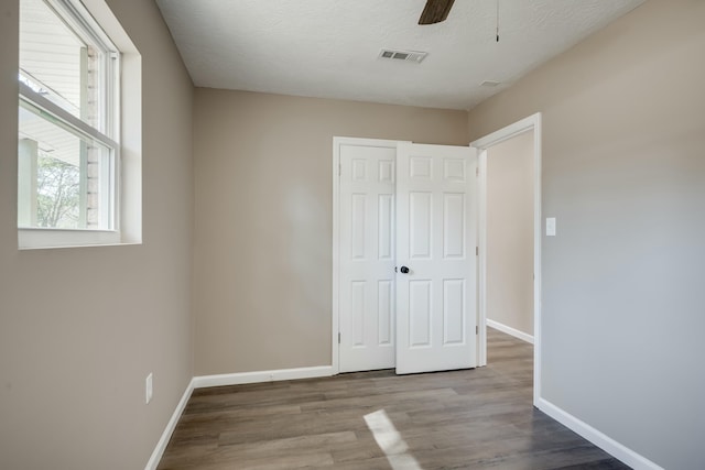 unfurnished bedroom with a closet, visible vents, baseboards, and light wood finished floors