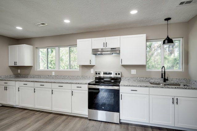 kitchen with stainless steel electric stove, white cabinetry, a sink, light stone countertops, and under cabinet range hood