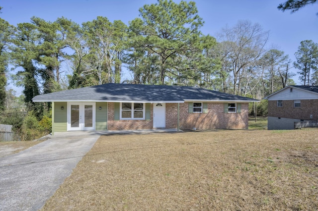 single story home with french doors, brick siding, and aphalt driveway