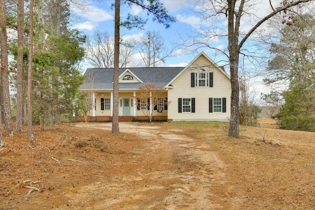 view of front of house featuring dirt driveway and a porch