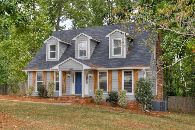 cape cod house with central AC and a front lawn