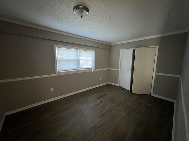 unfurnished bedroom with a textured ceiling, a closet, and dark wood-type flooring