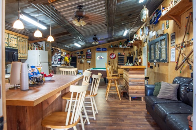 interior space with wooden walls, ceiling fan, white fridge, and pool table