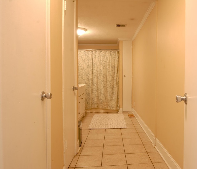 bathroom featuring tile patterned flooring, a textured ceiling, and ornamental molding