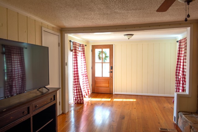 interior space featuring a textured ceiling, light hardwood / wood-style floors, and ceiling fan