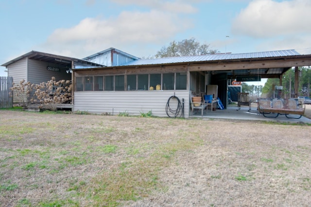 rear view of house with a patio area and a sunroom