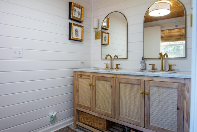 bathroom with vanity and wood walls