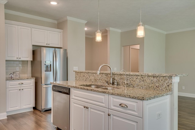 3109 Lobella Dr, Grovetown, GA 30813 - kitchen featuring appliances with stainless steel finishes, wood finished floors, a sink, ornamental molding, and a center island with sink