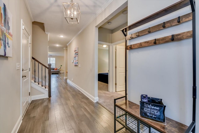 hall featuring crown molding, a notable chandelier, and hardwood / wood-style flooring