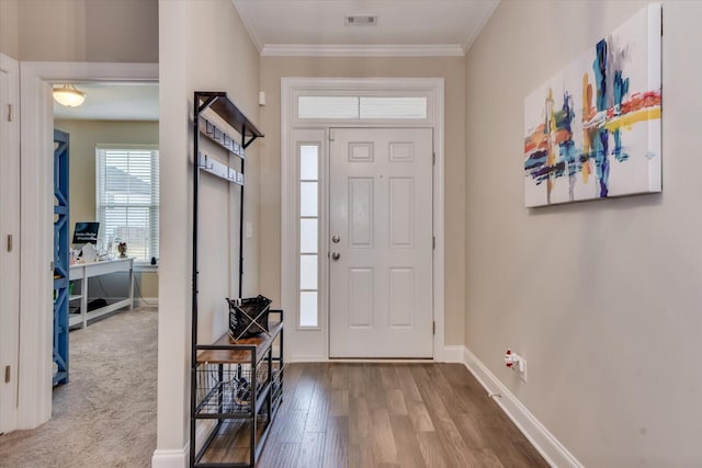 entryway with crown molding and light colored carpet