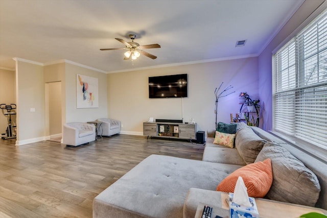 living room featuring ornamental molding, wood-type flooring, and ceiling fan